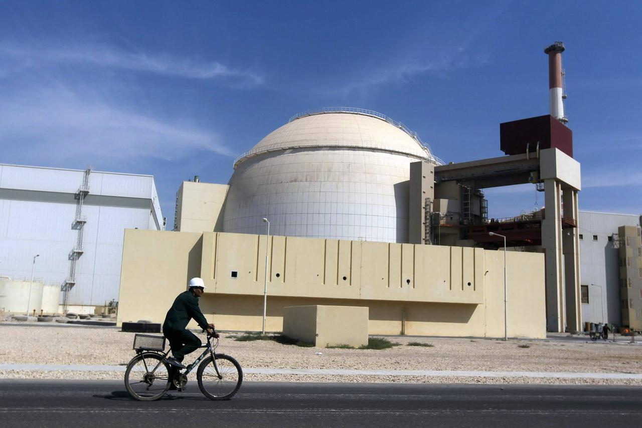 Arbeiter auf einem Fahrrad vor dem Atommeiler von Bushehr im Iran Arbeiter auf einem Fahrrad vor dem Atommeiler von Bushehr im Iran