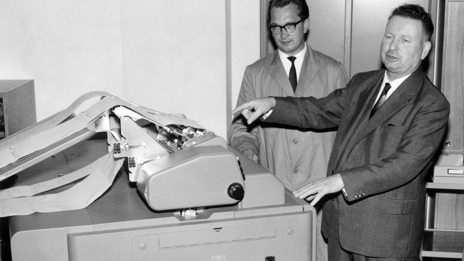 Anton Sabel (rechts) Präsident des Bundesamtes für Arbeitsvermittlung und Arbeitslosenunterstützung in Nürnberg (ab 1962 Bundesanstalt, ab 2002 Bundesagentur für Arbeit) setzt am 8. August 1961 eine Rechenmaschine in Gang, die täglich 45 000 Zahlungsanweisungen für Zweitkindergeld bearbeitet
