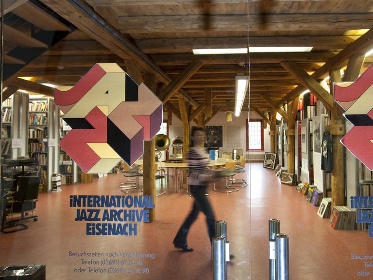 Blick in das Jazzarchiv. In einem Dachgeschoss mit Holzbalken stehen viele Regale mit Schallplatten und Büchern.