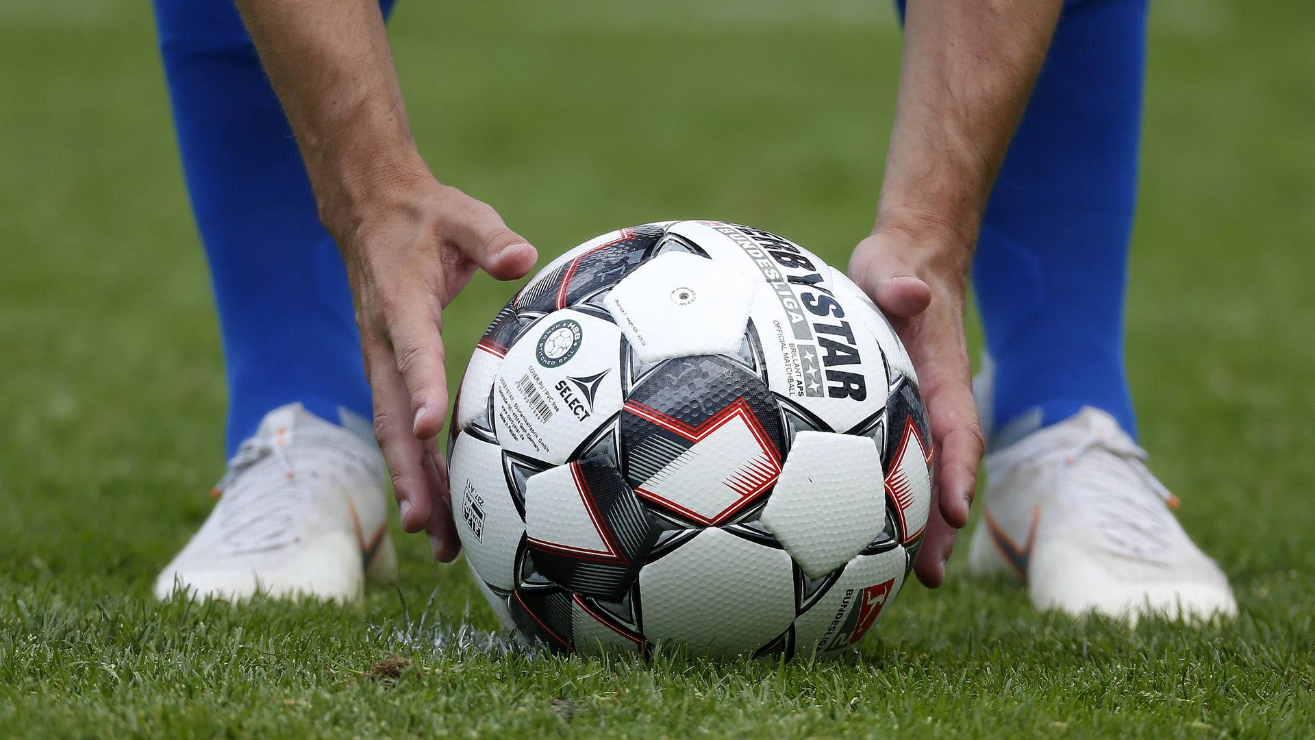 Ein Fußballprofi legt sich den Ball auf den Elfmeterpunkt. Ein Fußballprofi legt sich den Ball auf den Elfmeterpunkt.