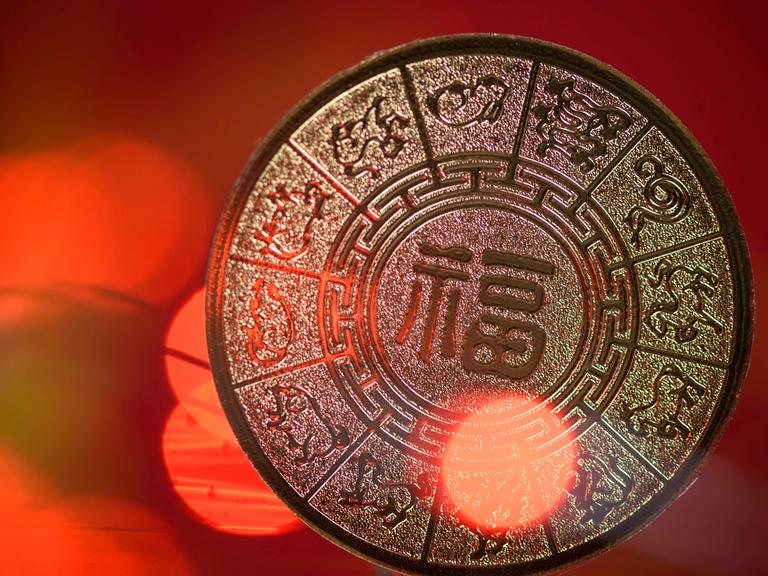 Die zwölf chinesischen Tierkreiszeichen auf einer glänzenden Münze.  