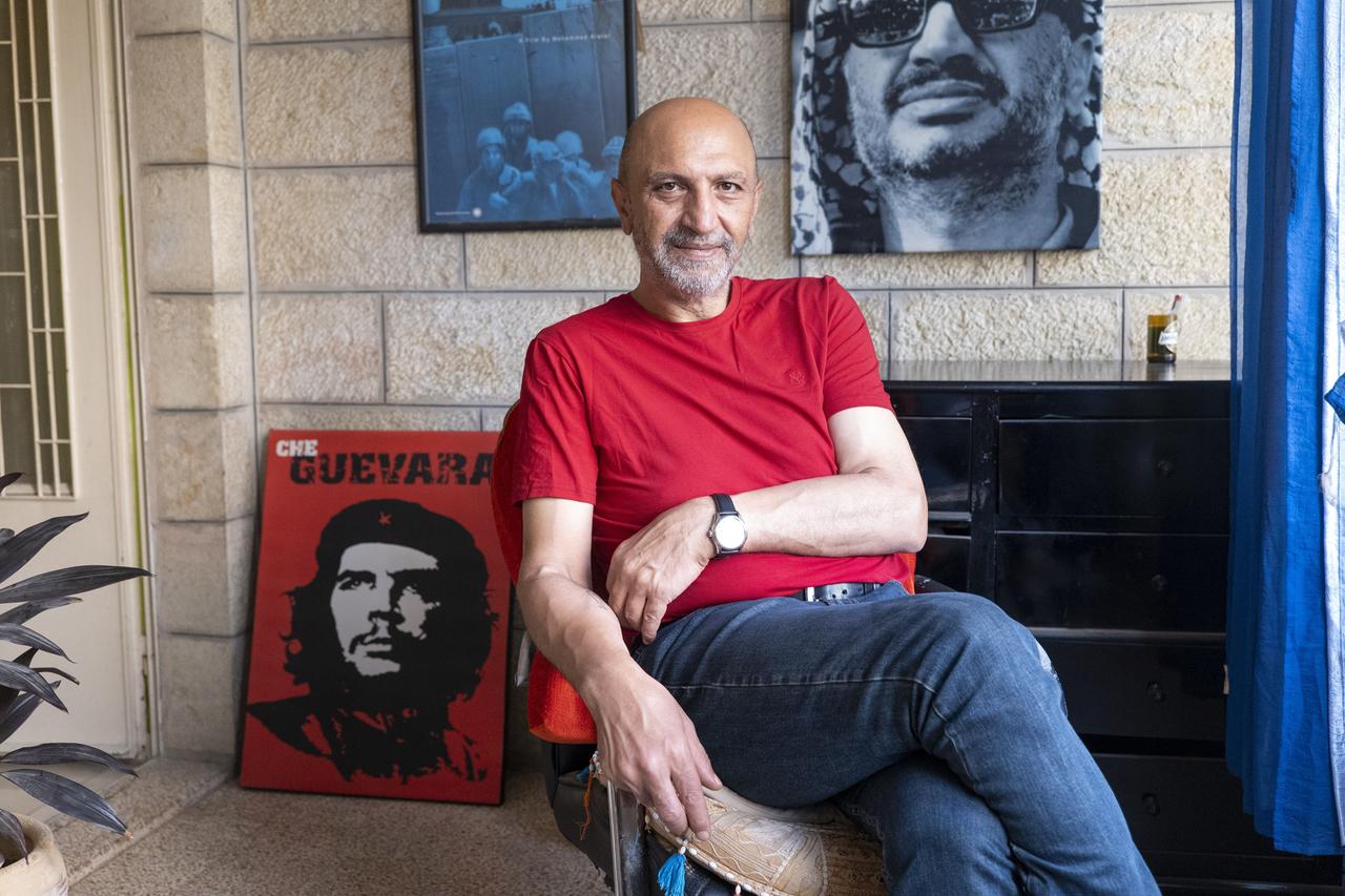 Ein Mann sitzt auf einem Stuhl, hinter ihm ein Che-Guevara-Plakat: der Filmemacher Mohammed Alatar.