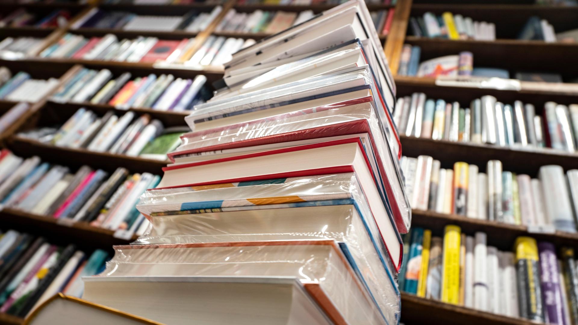 Ein Stapel neuer Bücher liegt auf einem Verkaufstisch in einer Buchhandlung Ein Stapel neuer Bücher liegt auf einem Verkaufstisch in einer Buchhandlung
