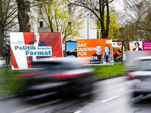 Wahlplakate verschiedener Parteien stehen an einer Straße in Bremen.