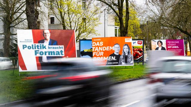 Wahlplakate verschiedener Parteien stehen an einer Straße in Bremen.