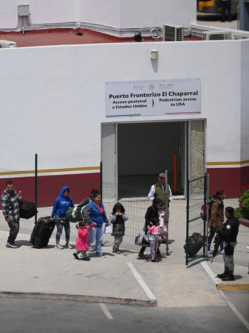 Eine geordnete Menschenschlange steht am Grenzübergang zwischen Mexiko und den USA.