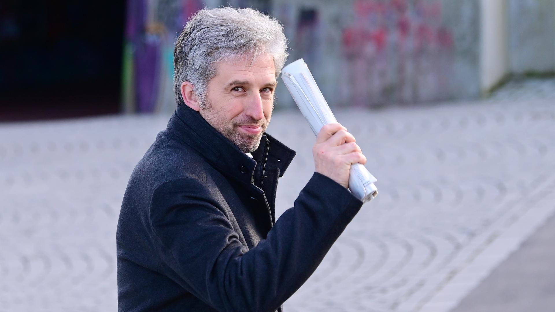Tübingens Oberbürgermeister Boris Palmer winkt mit einem zusammengerollten Papierstapel in die Kamera. Tübingens Oberbürgermeister Boris Palmer winkt mit einem zusammengerollten Papierstapel in die Kamera.