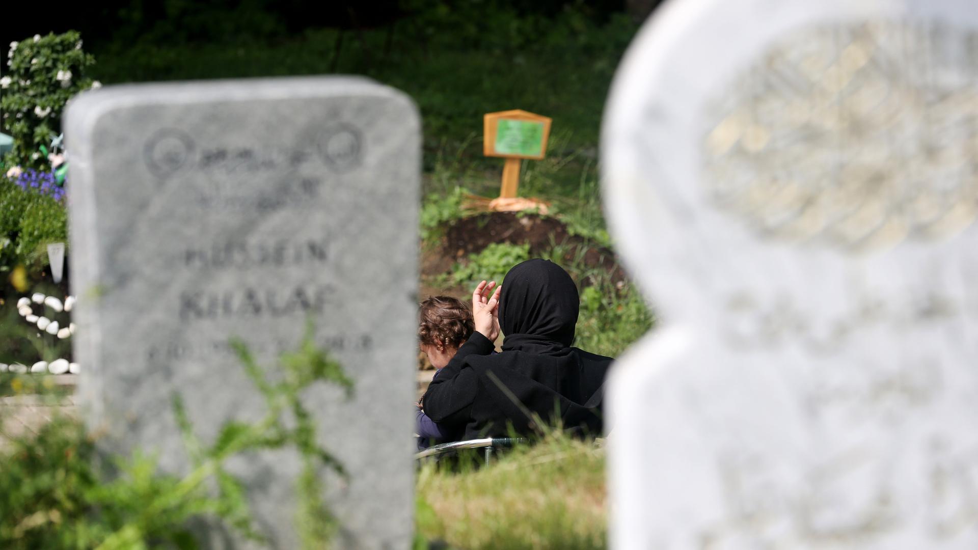 Eine muslimische Mutter und ihre Tochter besuchen ein Grab auf dem islamischen Gräberfeld am Friedhof am Hügel Hallo in Essen. Eine muslimische Mutter und ihre Tochter besuchen ein Grab auf dem islamischen Gräberfeld am Friedhof am Hügel Hallo in Essen.