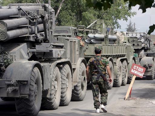 Ein Soldat neben einer Panzerkolonne