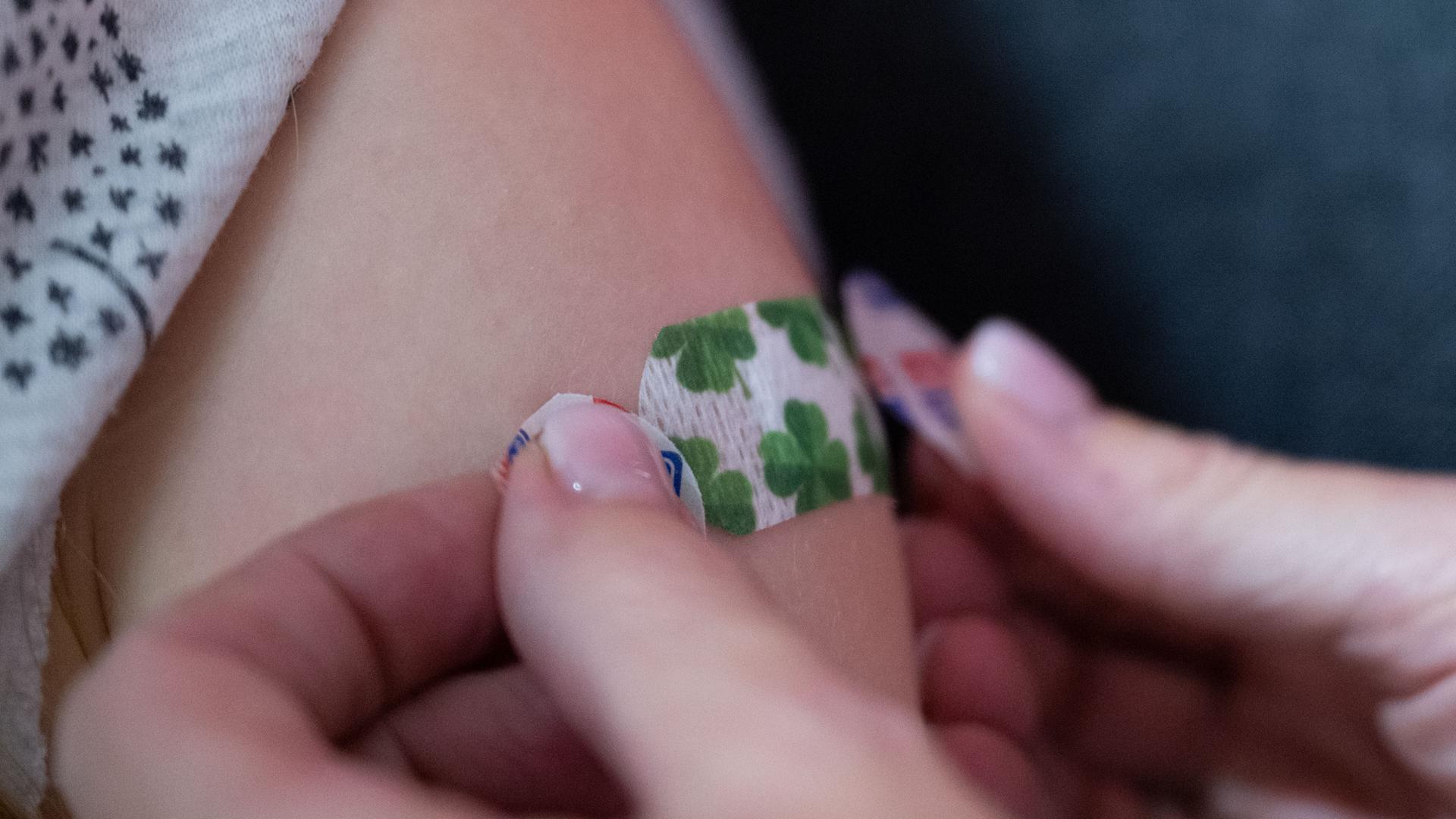 Eine Impfärztin klebt an einem Impfstützpunkt mit dem Titel "Impfpünktchen" der Stadt Heilbronn bei einer Kinderimpfung ein Pflaster auf den Oberarm eines Kindes. Eine Impfärztin klebt an einem Impfstützpunkt mit dem Titel "Impfpünktchen" der Stadt Heilbronn bei einer Kinderimpfung ein Pflaster auf den Oberarm eines Kindes.