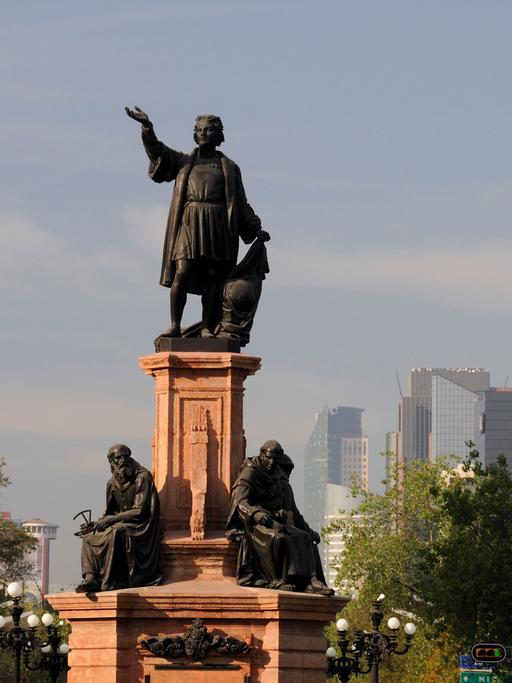 Die Statue des Kolumbus-Denkmals ragt zwischen modernen Bauten in Mexiko-Stadt hervor.