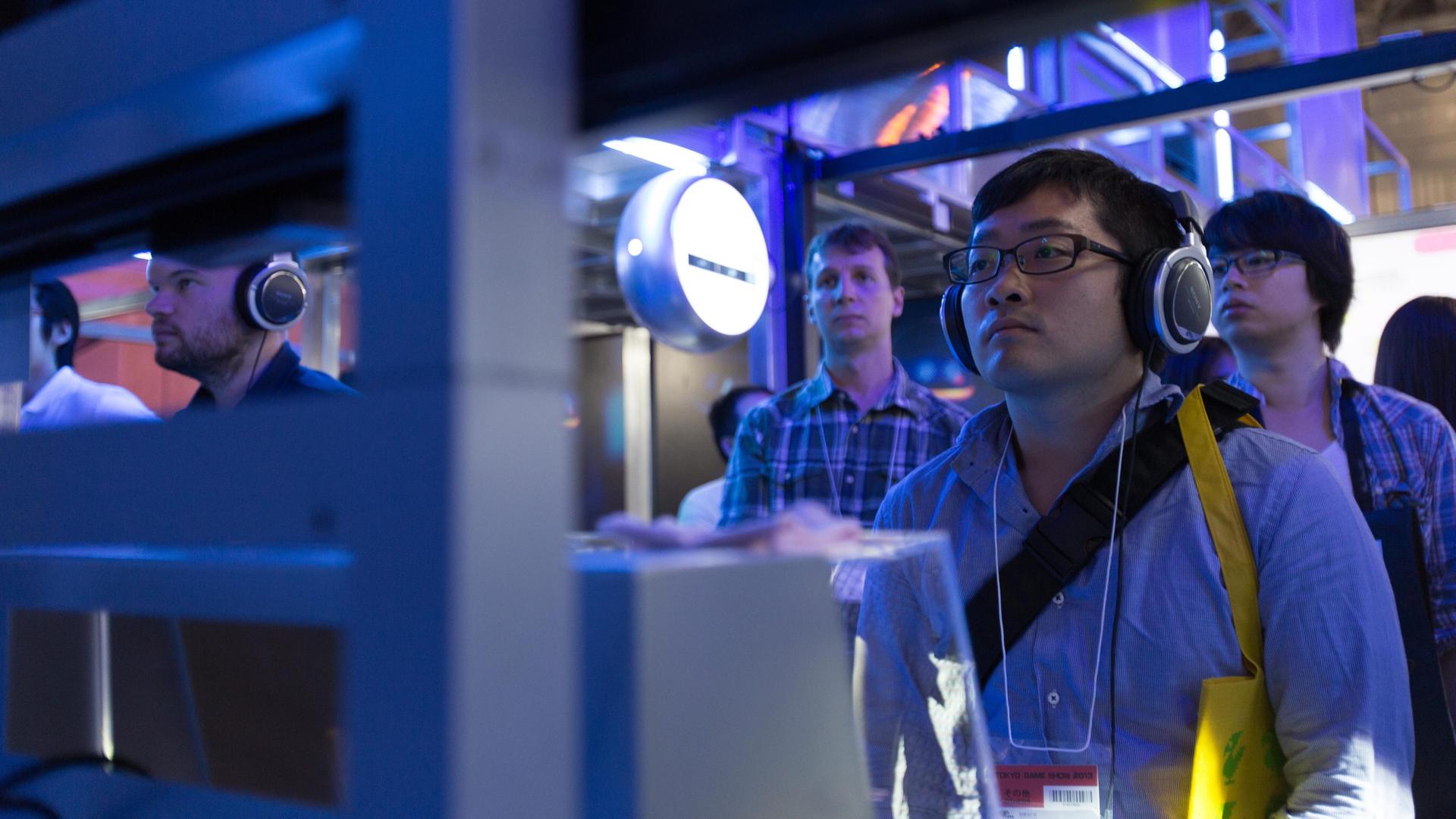 Gamer schauen bei einer PC-Spiele-Messe auf ihre großen Bildschirme. Gamer schauen bei einer PC-Spiele-Messe auf ihre großen Bildschirme.