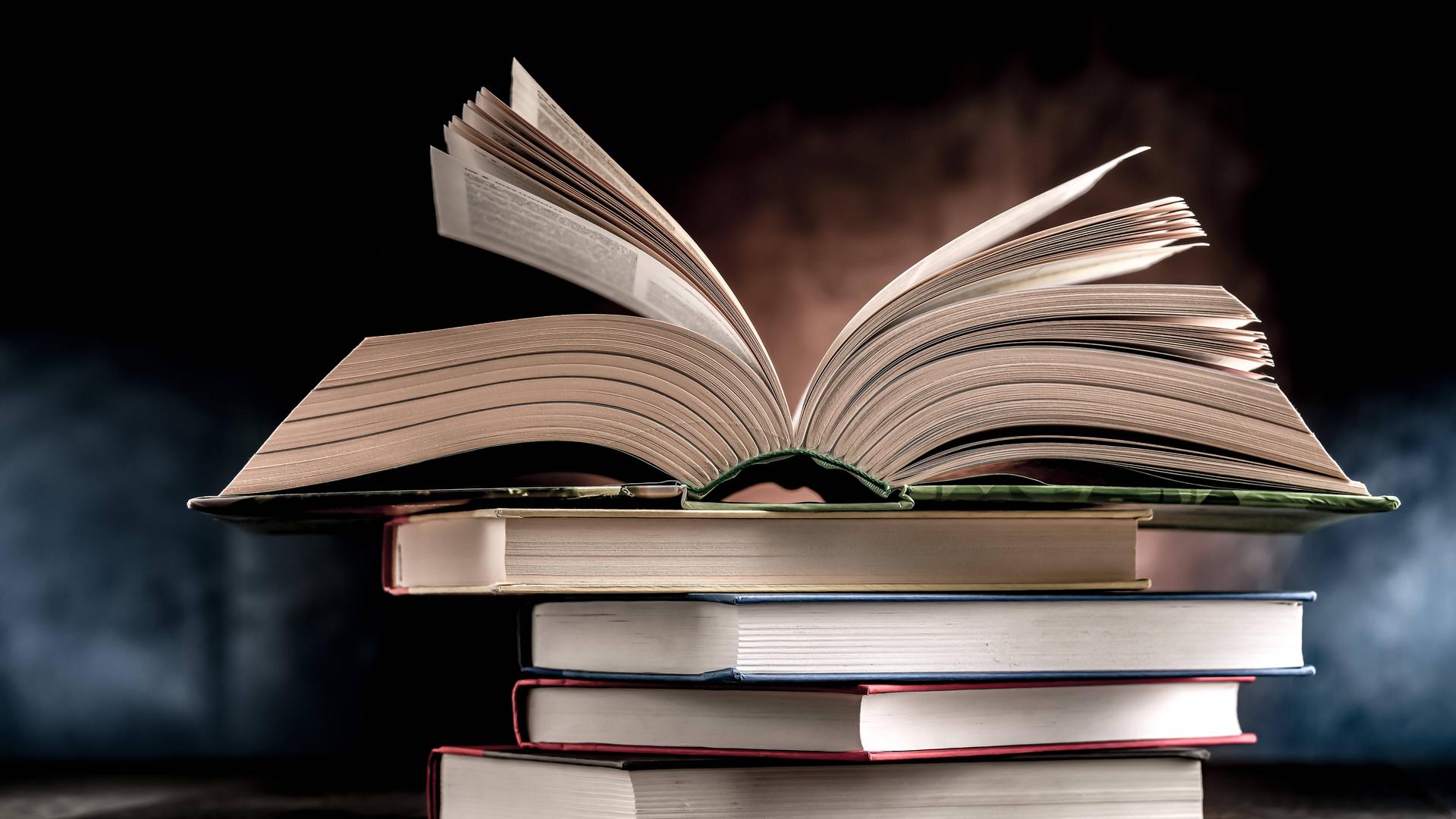 Ein Bücherstapel, das oberste Buch ist aufgeschlagen. Ein Bücherstapel, das oberste Buch ist aufgeschlagen.