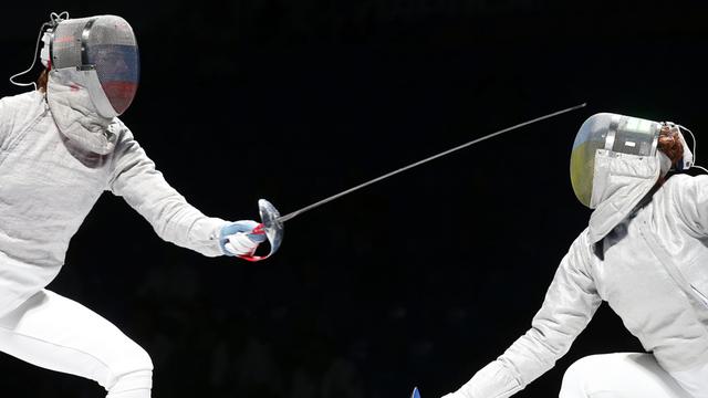 Die russische Fechtrin Yana Egorian (L) im Kampf gegen die Ukrainerin Alina Komashchuk (R) - beide tragen ihre Masken mit den jeweiligen Landesflaggen