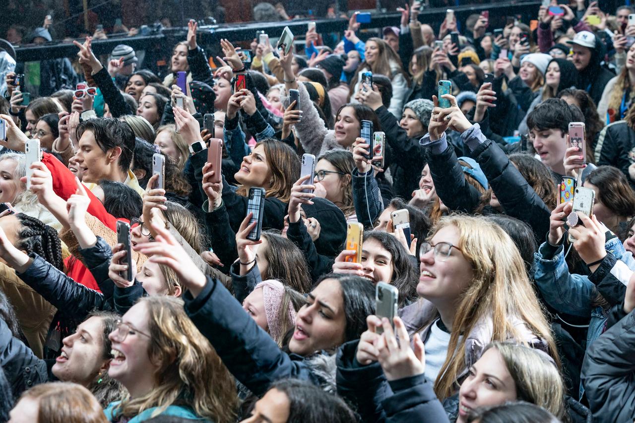 Eine Gruppe von Harry Styles Fans, alle halten ihre Smartphones hoch und fotografieren und filmen. Eine Gruppe von Harry Styles Fans, alle halten ihre Smartphones hoch und fotografieren und filmen.