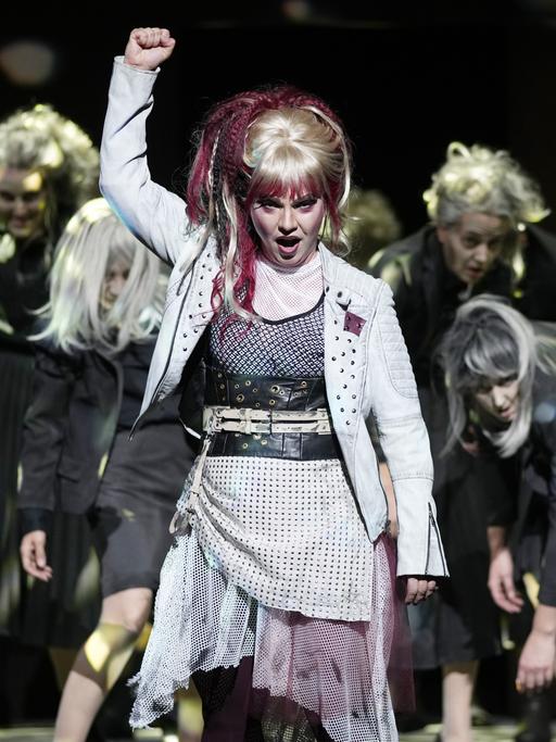 Eine Frau auf der Bühne reckt kämpferisch die Faust in die Höhe.