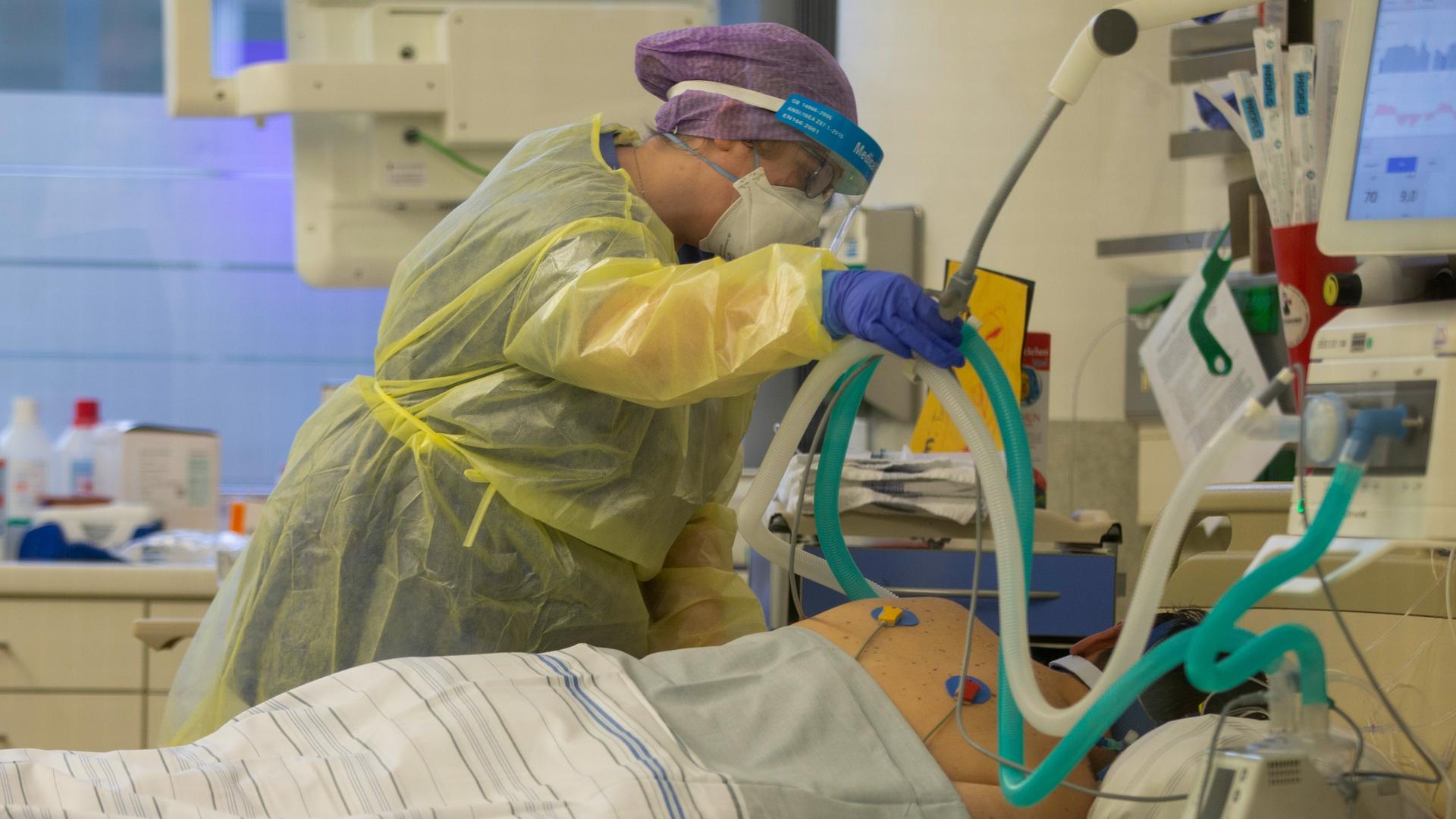 Eine Krankenschwester betreut auf einer Intensivstation einen Covidpatienten, der künstlich beatmet wird. 