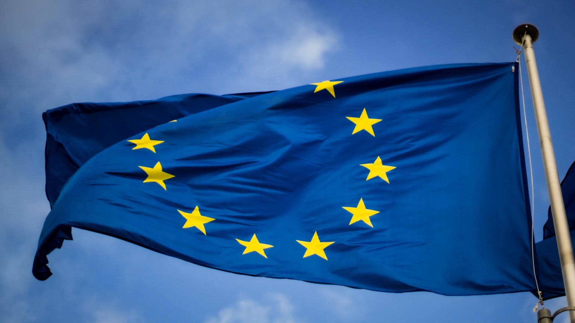 Eine Europa-Flagge weht vor blauem Himmel