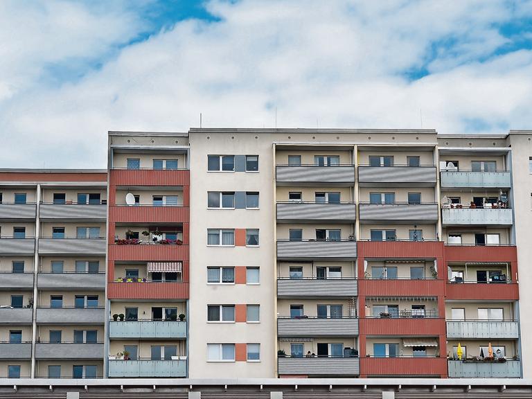 Plattenbauten in der Zossener Straße in Berlin-Hellersdorf: Ein Häuserblock mit Balkonen, die unterschiedliche Farben haben.