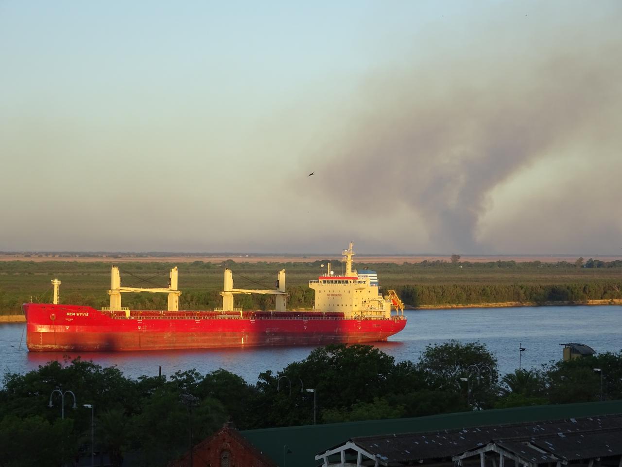 Ein großes Schiff auf einem Fluss bläst dunklen Rauch in die Luft