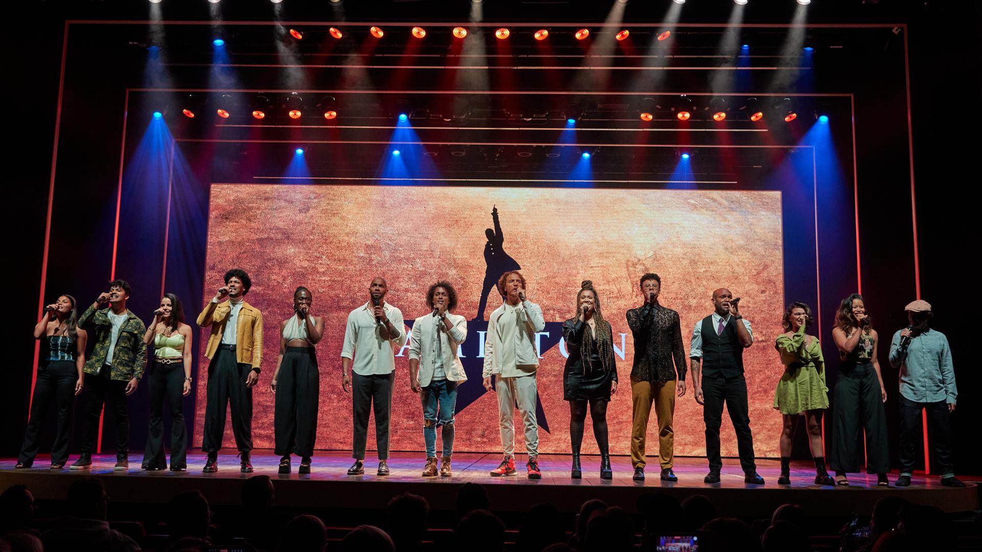 Musical-Hauptdarsteller Benét Monteiro steht zusammen mit dem Ensemble während eines Pressetermins zur deutschen Produktion des Broadway-Musicals "Hamilton" im Operettenhaus auf der Bühne. Musical-Hauptdarsteller Benét Monteiro steht zusammen mit dem Ensemble während eines Pressetermins zur deutschen Produktion des Broadway-Musicals "Hamilton" im Operettenhaus auf der Bühne.