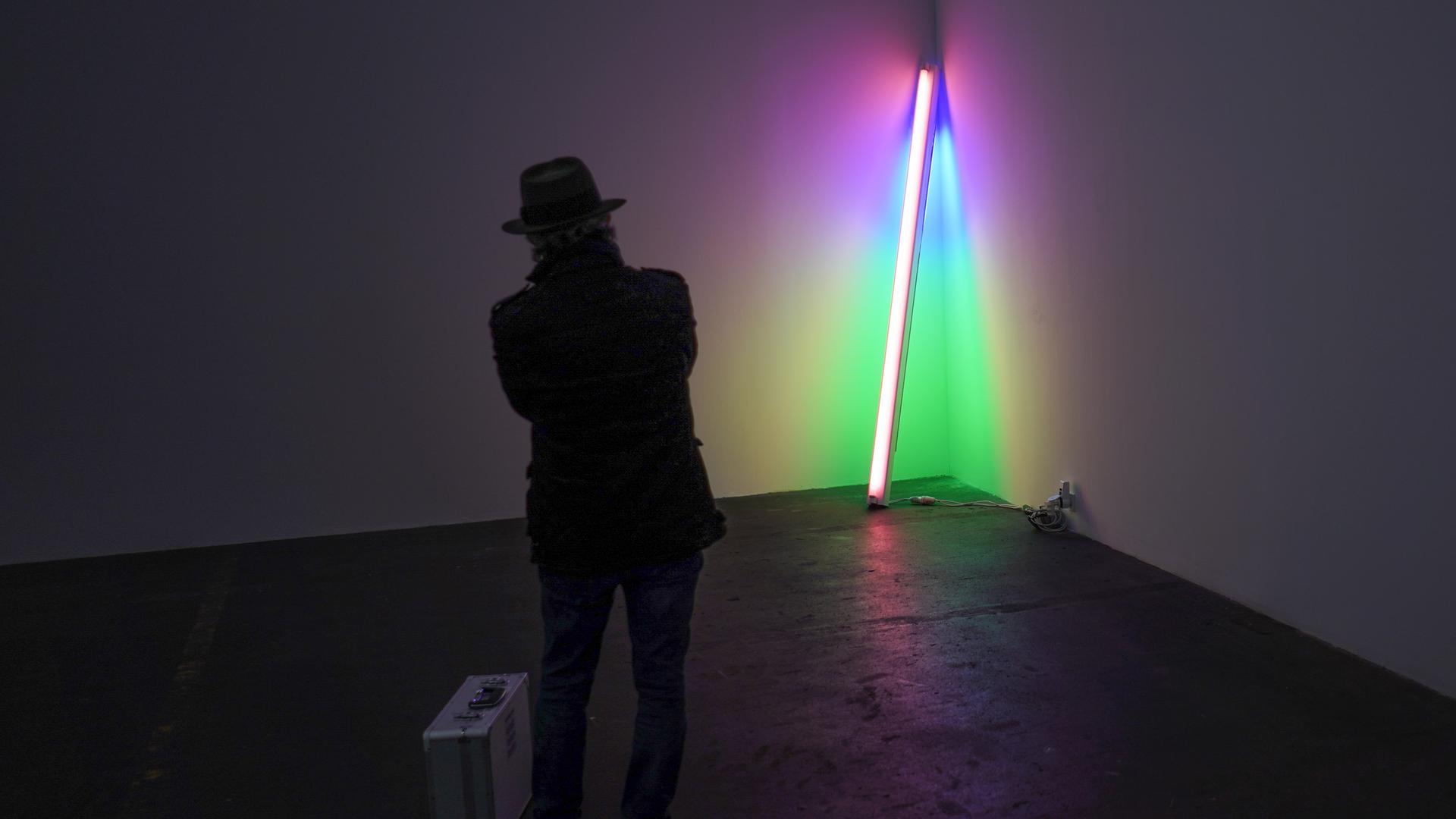 Ein Museumsbesucher betrachtet ein Werk von Dan Flavin. Ein Museumsbesucher betrachtet ein Werk von Dan Flavin.