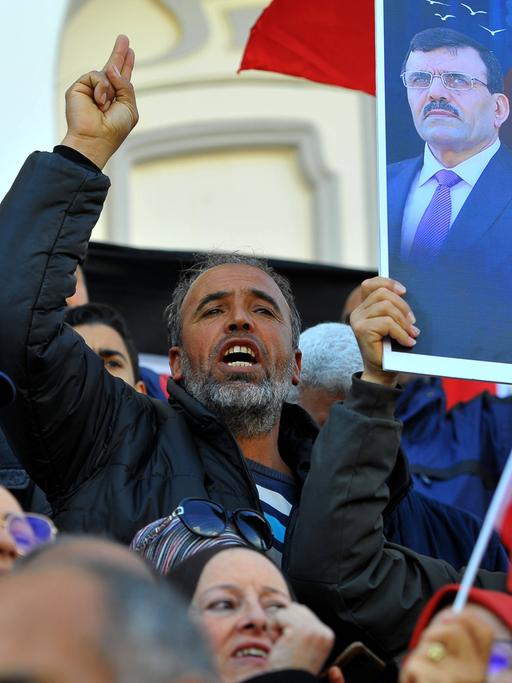 Antiregierungsproteste in Tunesien: Menschen demonstrieren, skandieren, halten Schilder hoch.