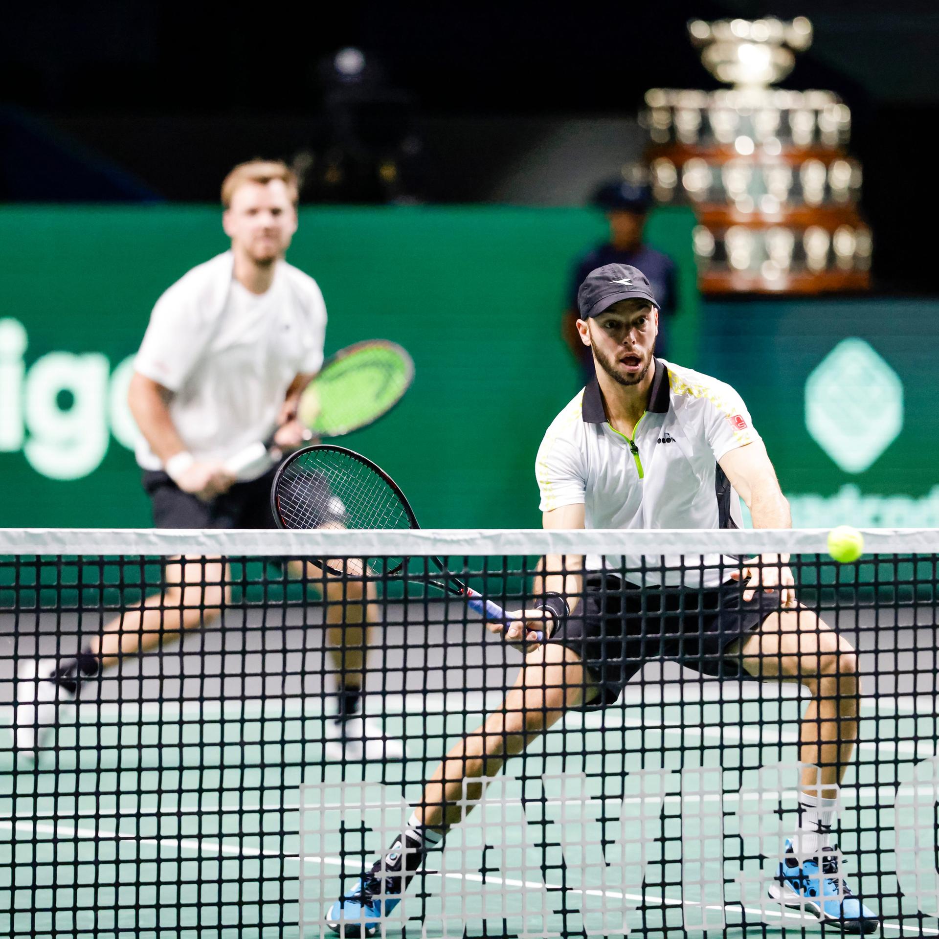 Zwei Männer hinter einem Tennisnetz in Aktion