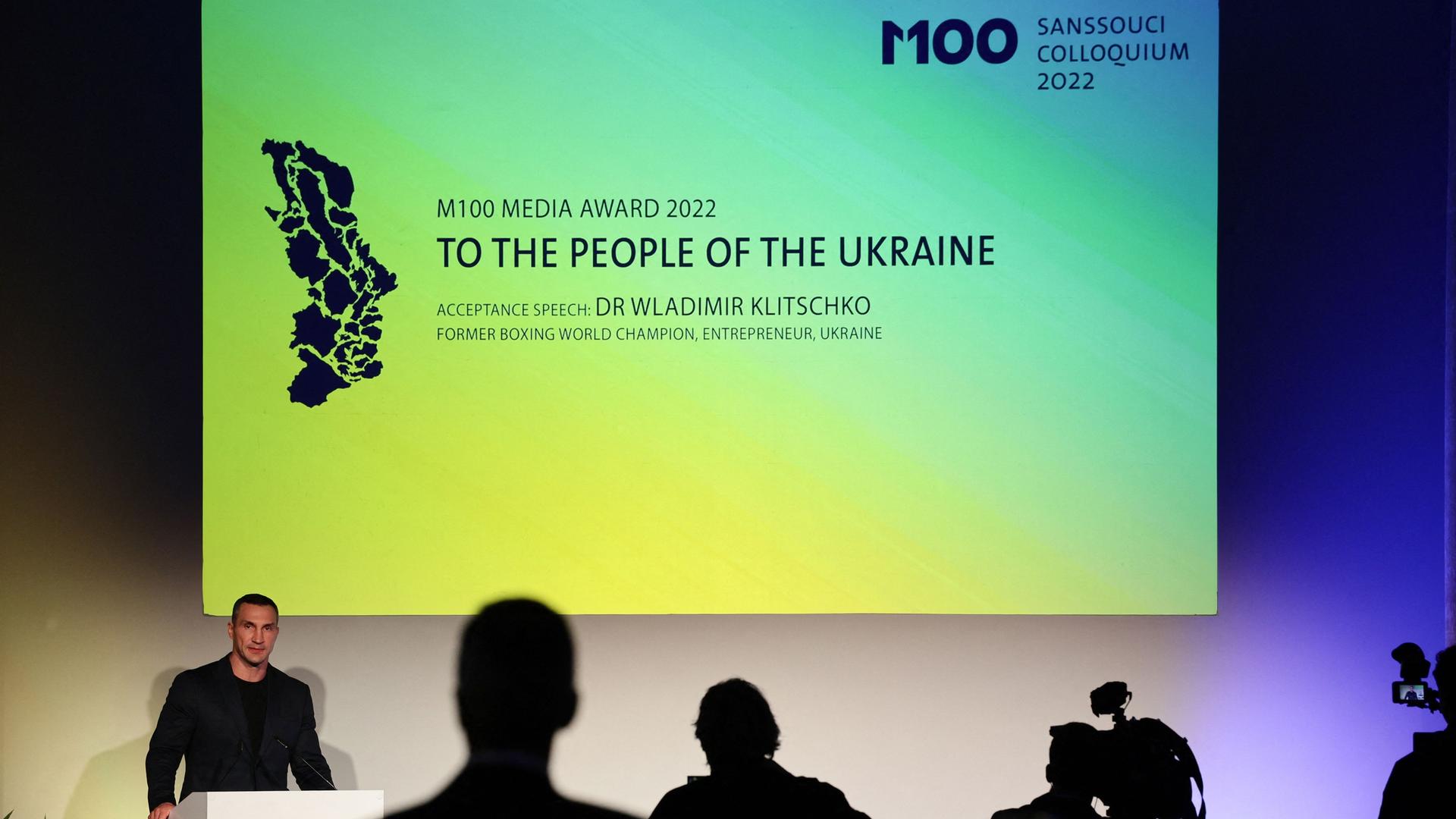 Der frühere Schwergewichts-Boxer Wladimir Klitschko bei der Verleihung in Potsdam am Rednerpult, hinter ihm eine Leinwand mit der Aufschrift: "M100 Media Award - To the people of the Ukraine"