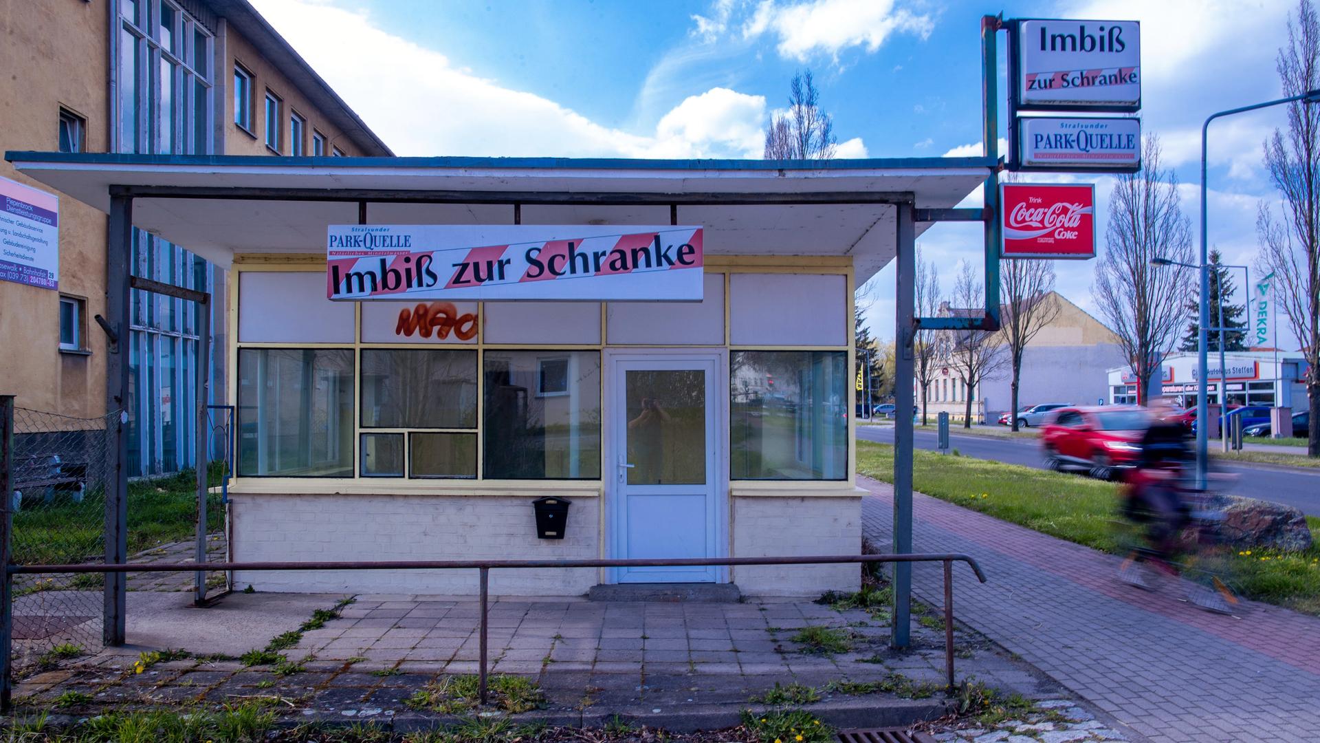 Ein Radfahrer fährt an einem leerstehenden Schnellimbiss vorbei.