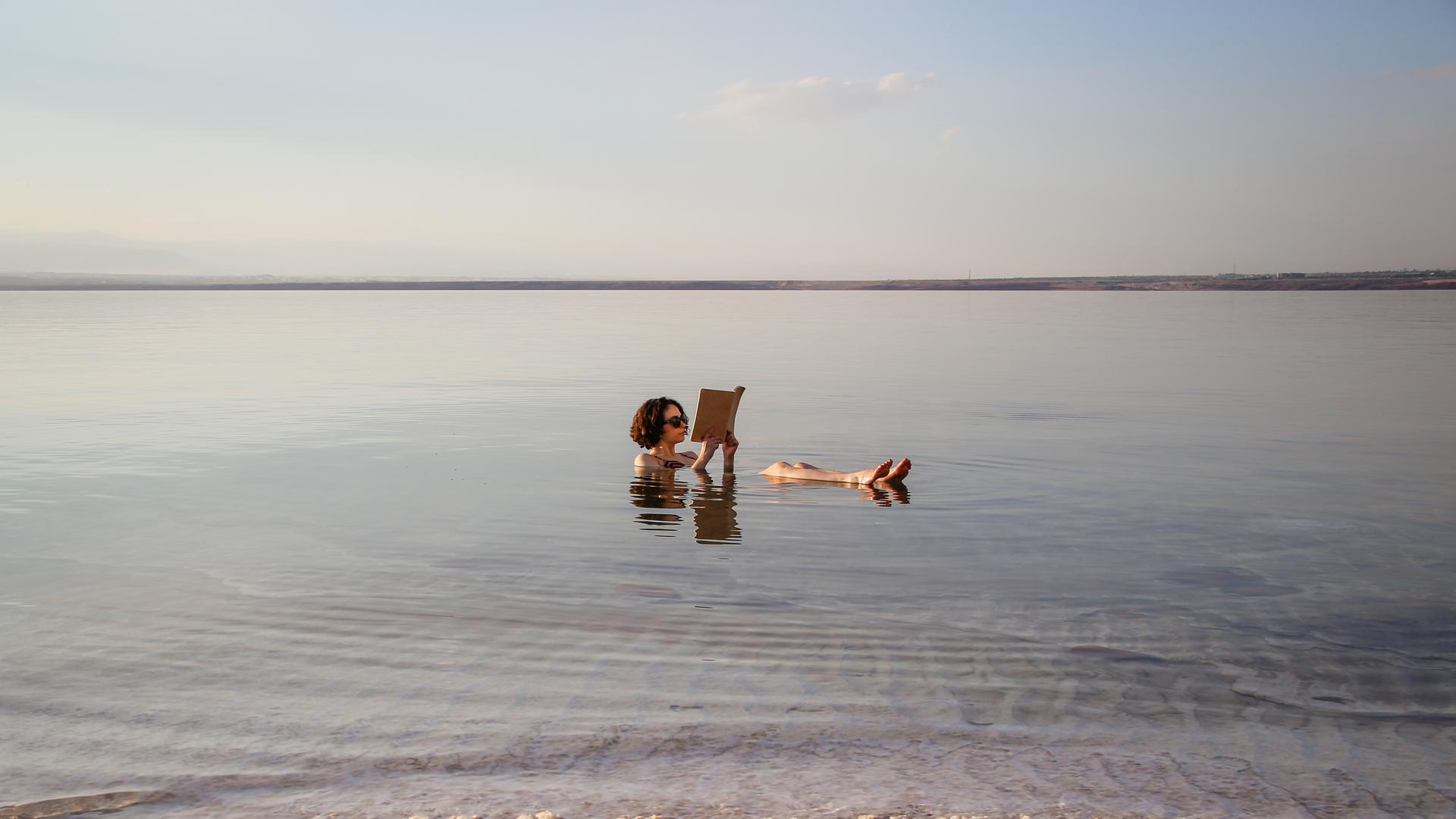 Eine Frau liest ein Buch im Toten Meer in Jordanien. Eine Frau liest ein Buch im Toten Meer in Jordanien.