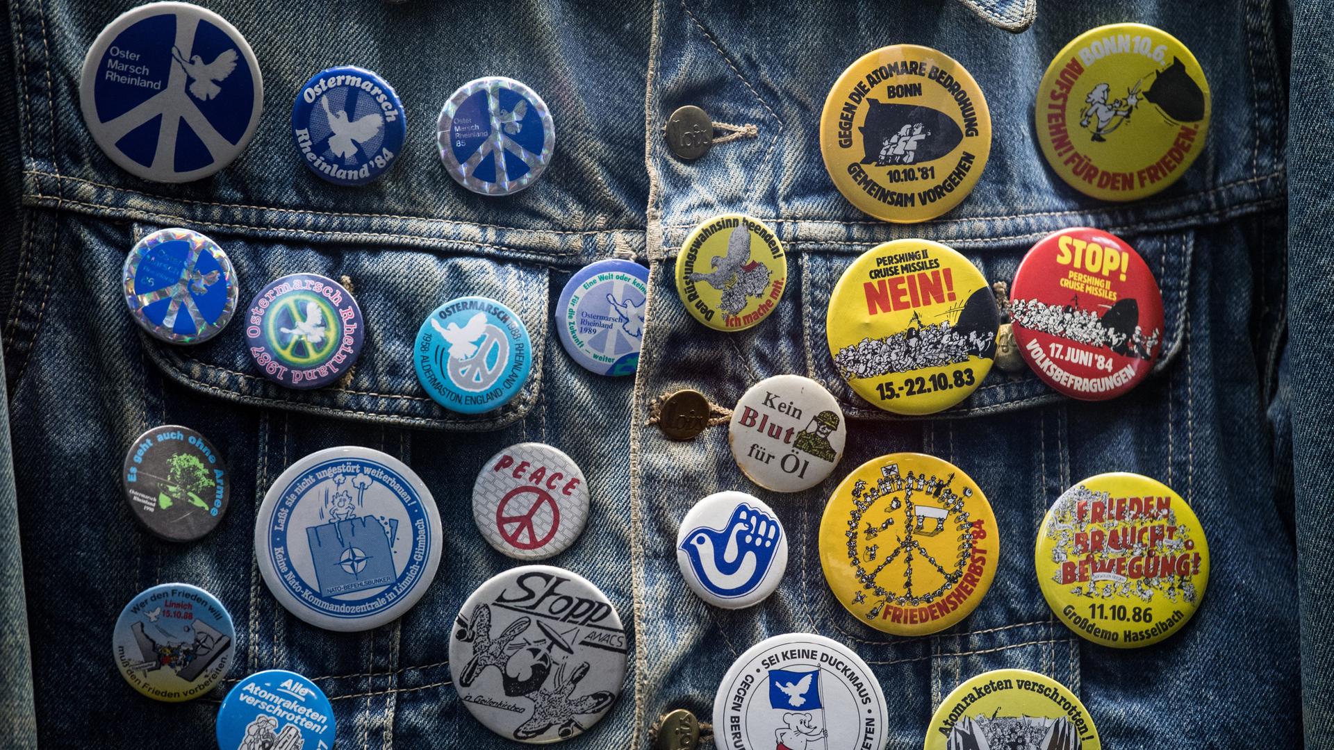 Anstecker für den Frieden auf einer Jeansjacke Anstecker für den Frieden auf einer Jeansjacke