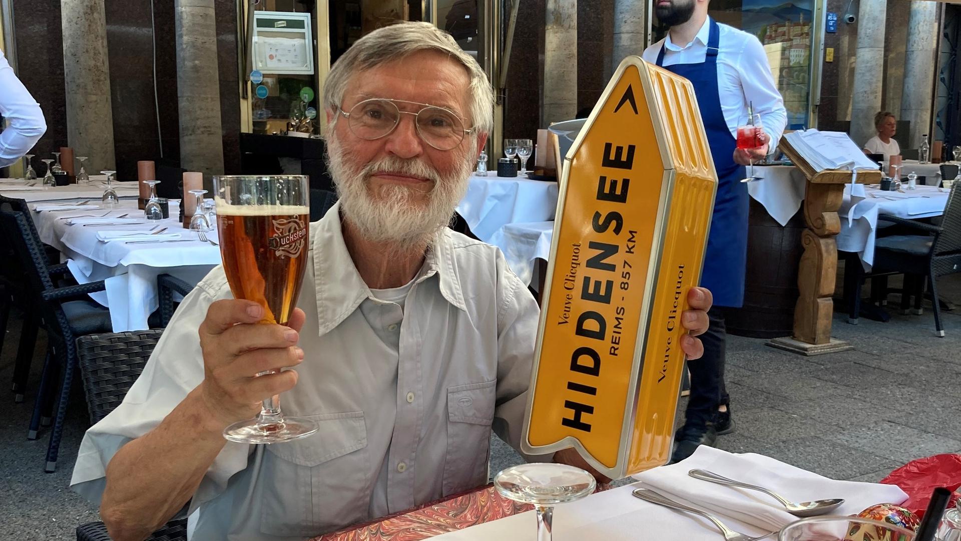Rainer Menschik sitzt auf der Terrasse eines Restaurants Rainer Menschik sitzt auf der Terrasse eines Restaurants