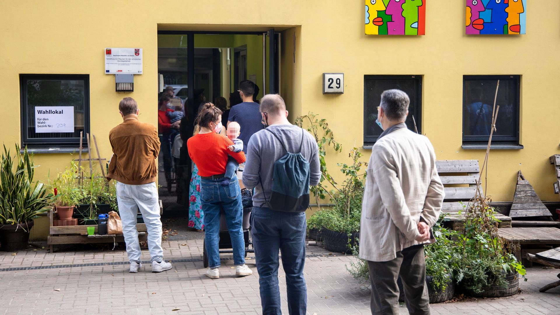 Menschen warten in der Stadt Berlin vor einem Wahl-Lokal. Menschen warten in der Stadt Berlin vor einem Wahl-Lokal.