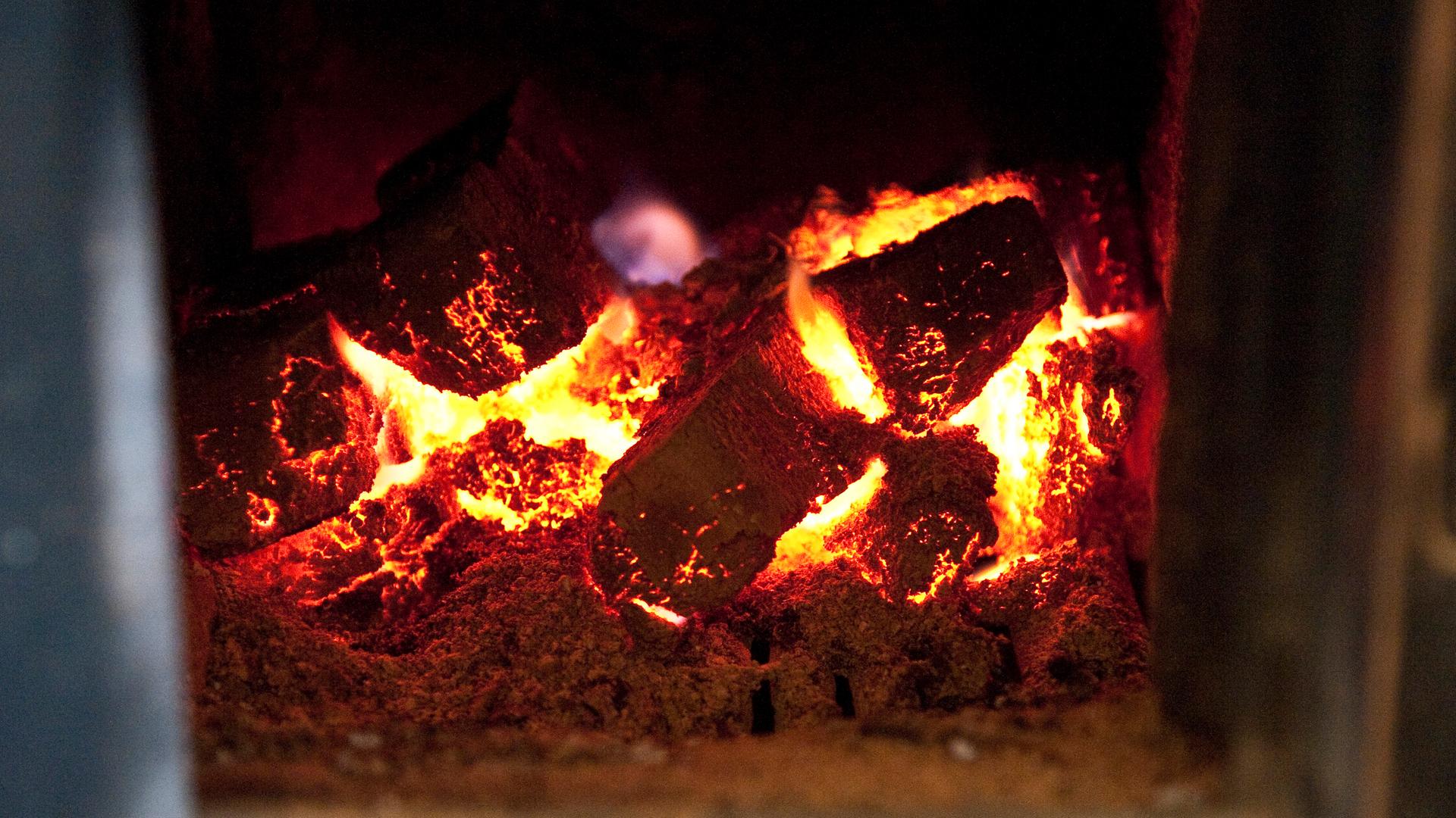 Braunkohlebriketts glühen in einem Kachelofen. Braunkohlebriketts glühen in einem Kachelofen.