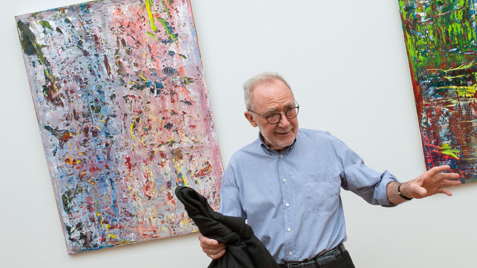 Der Maler Gerhard Richter steht vor abstrakten Gemälden