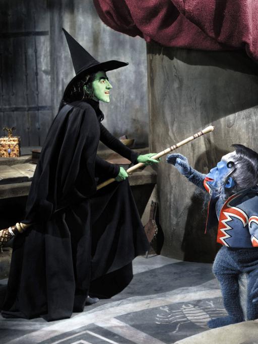Die böse Hexe des Westens im Kultfilm "Wizard of Oz", wie in der Klischeevorstellung auf dem Besen reitend. 