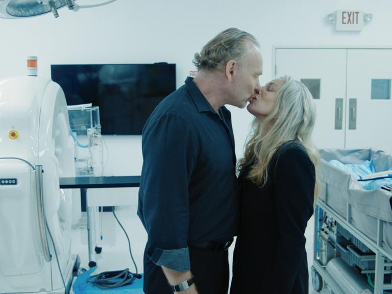 Ein Mann und eine Frau küssen sich in einem Labor.