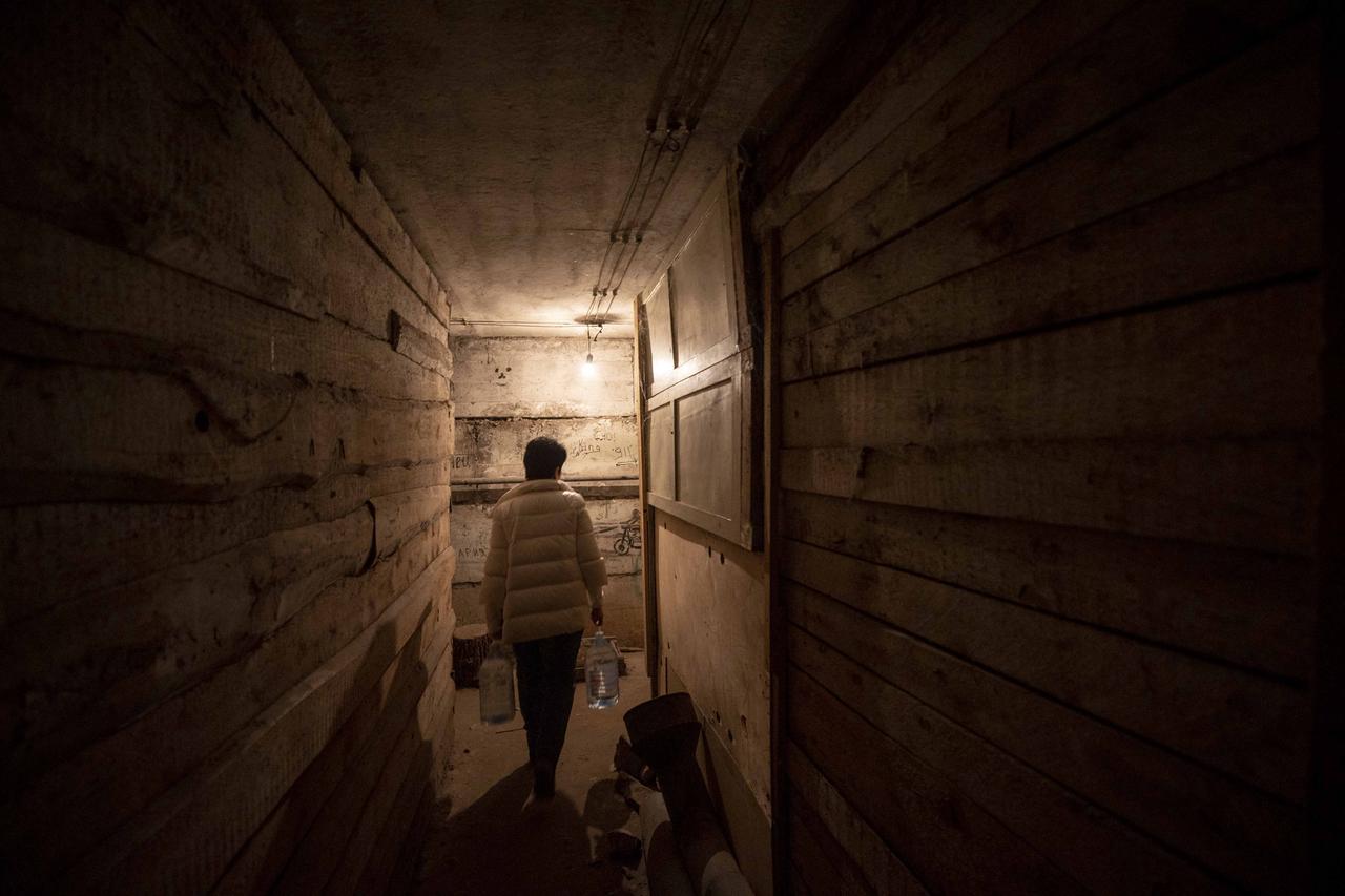 Eine Frau sucht Schutz vor dem Krieg in der Ukraine in einem Keller. Eine Frau sucht Schutz vor dem Krieg in der Ukraine in einem Keller.