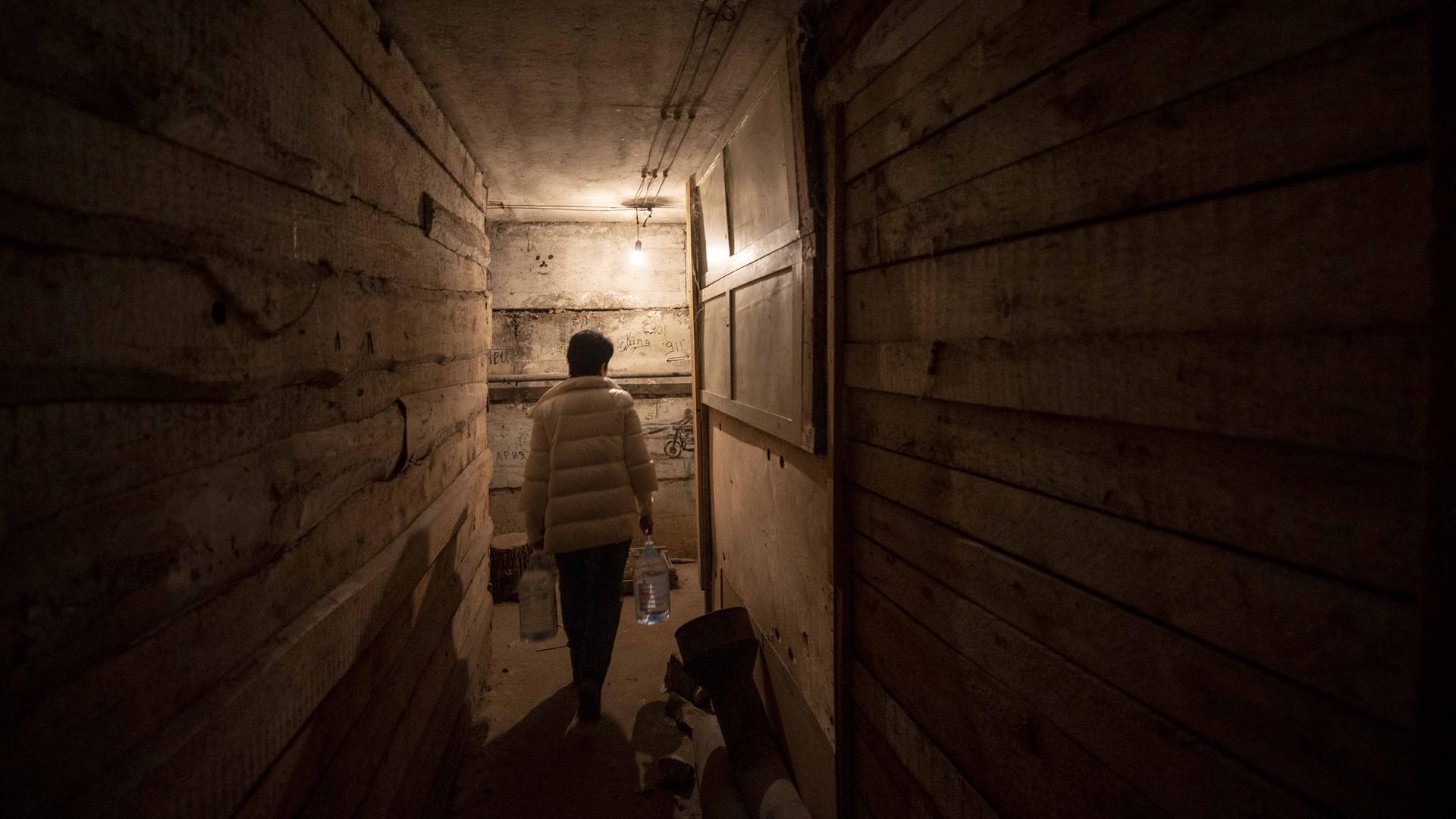 Eine Frau sucht Schutz vor dem Krieg in der Ukraine in einem Keller. Eine Frau sucht Schutz vor dem Krieg in der Ukraine in einem Keller.