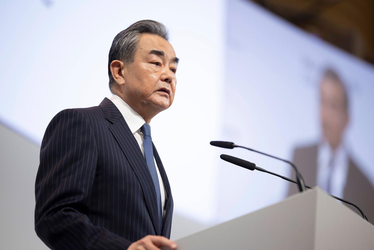 Der chinesische Außenpolitiker Wang Yi spricht bei der Münchner Sicherheitskonferenz 2023 an einem Redepult mit Mikrofonen. Über ihm ist eine Videoübertragung seiner Rede zu sehen. Der chinesische Außenpolitiker Wang Yi spricht bei der Münchner Sicherheitskonferenz 2023 an einem Redepult mit Mikrofonen. Über ihm ist eine Videoübertragung seiner Rede zu sehen.