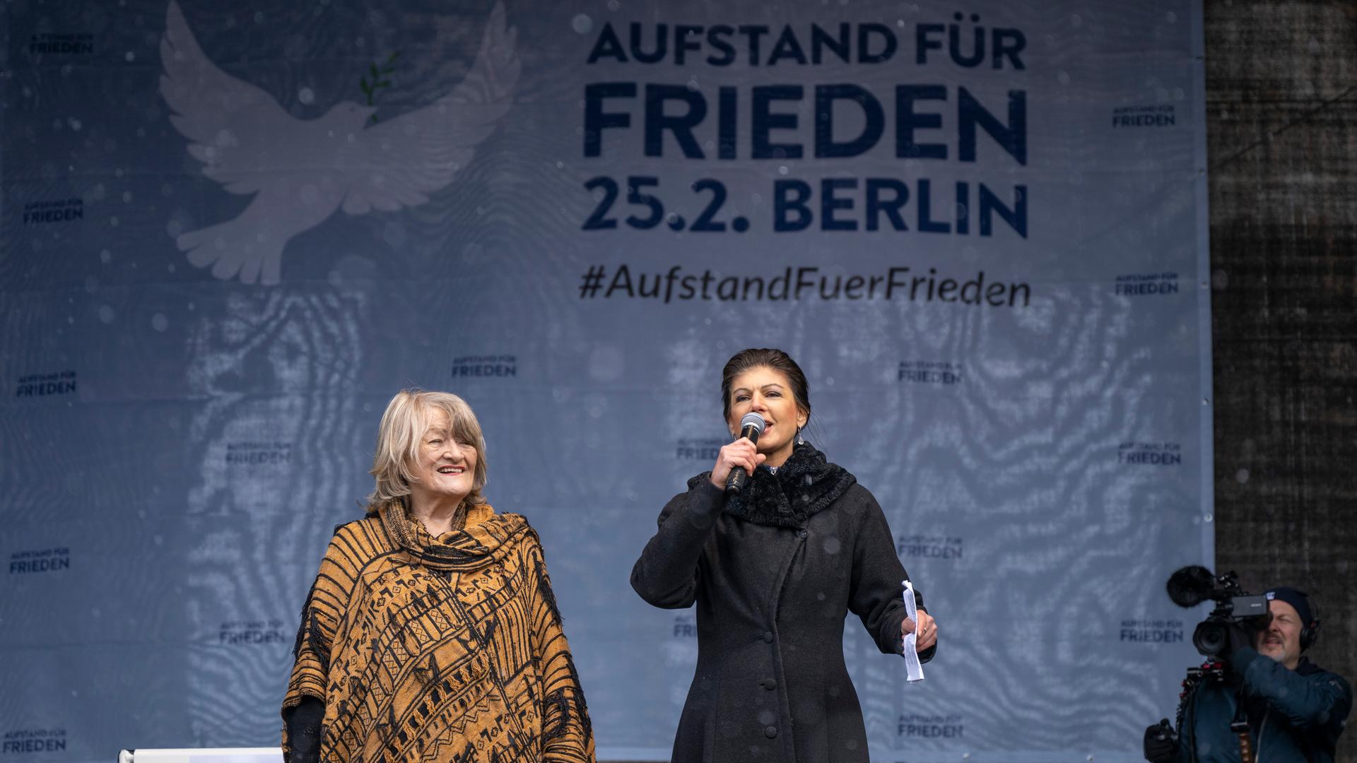 Alice Schwarzer (l), Frauenrechtlerin, und Sahra Wagenknecht (Die Linke), stehen bei der Demonstration "Aufstand für den Frieden" auf der Bühne. Alice Schwarzer (l), Frauenrechtlerin, und Sahra Wagenknecht (Die Linke), stehen bei der Demonstration "Aufstand für den Frieden" auf der Bühne.