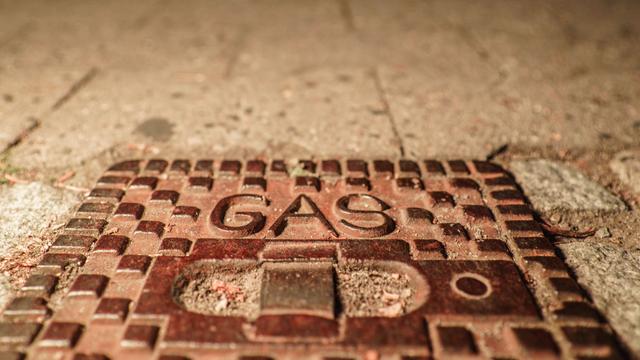 Das Wort "Gas" steht auf einem Deckel über einer Gasleitung auf einem Frankfurter Gehweg.