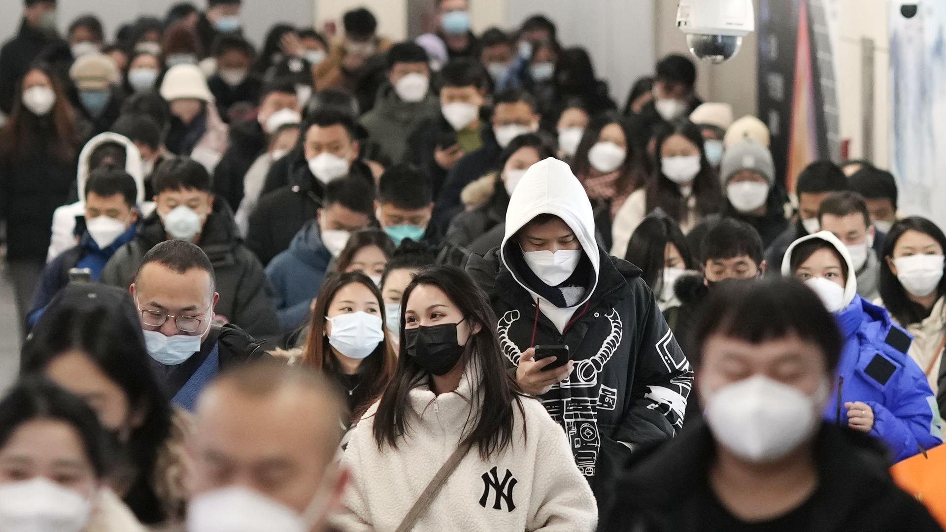 Peking: Menschen mit Mund-Nasen-Schutz gehen während der Hauptverkehrszeit durch eine U-Bahn-Station. Peking: Menschen mit Mund-Nasen-Schutz gehen während der Hauptverkehrszeit durch eine U-Bahn-Station.