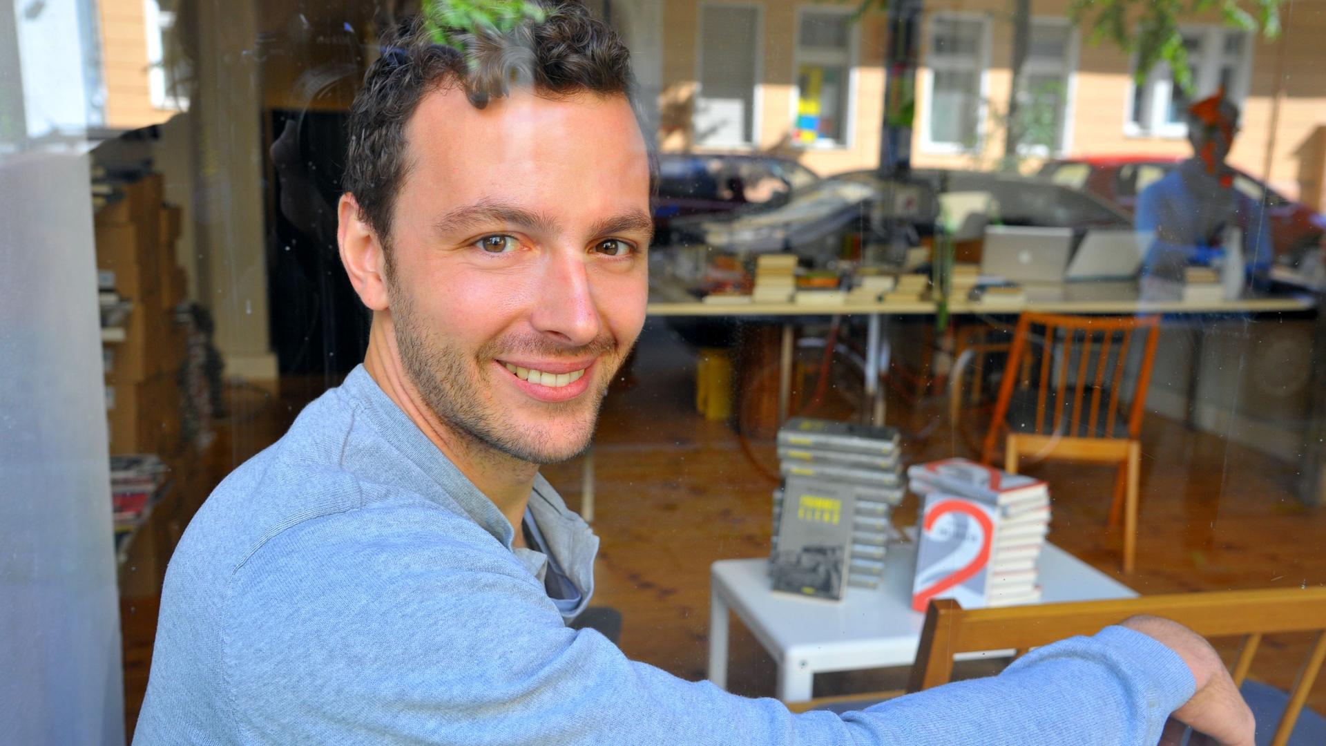 Der Verleger Sebastian Guggolz sitzt in der Geschäftsstelle des Guggolz-Verlags in Berlin-Schöneberg, im Hintergrund Bücherstapel. Der Verleger Sebastian Guggolz sitzt in der Geschäftsstelle des Guggolz-Verlags in Berlin-Schöneberg, im Hintergrund Bücherstapel.