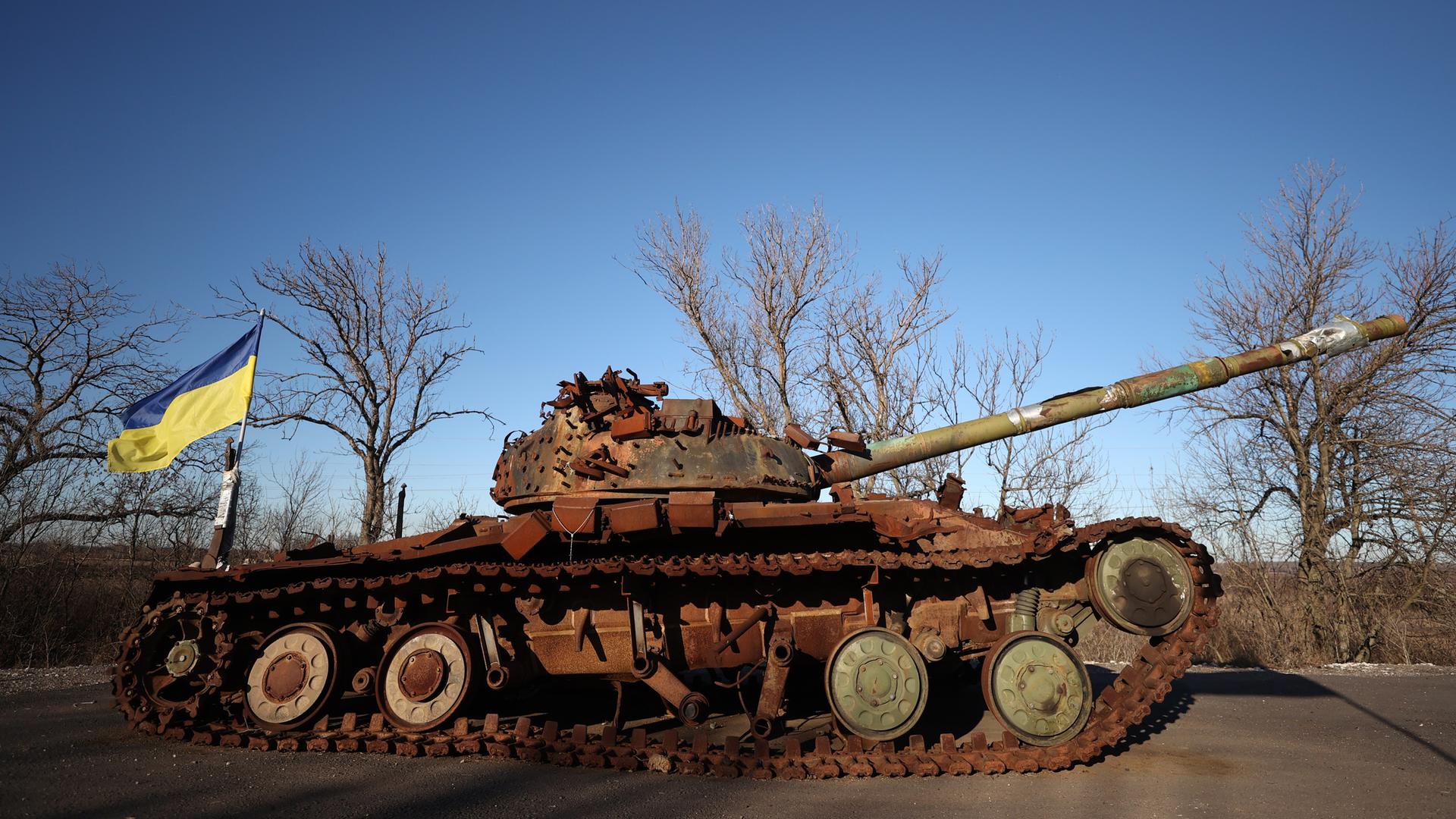 Ein verrosteter Panzer mit Ukraine-Fahne Ein verrosteter Panzer mit Ukraine-Fahne