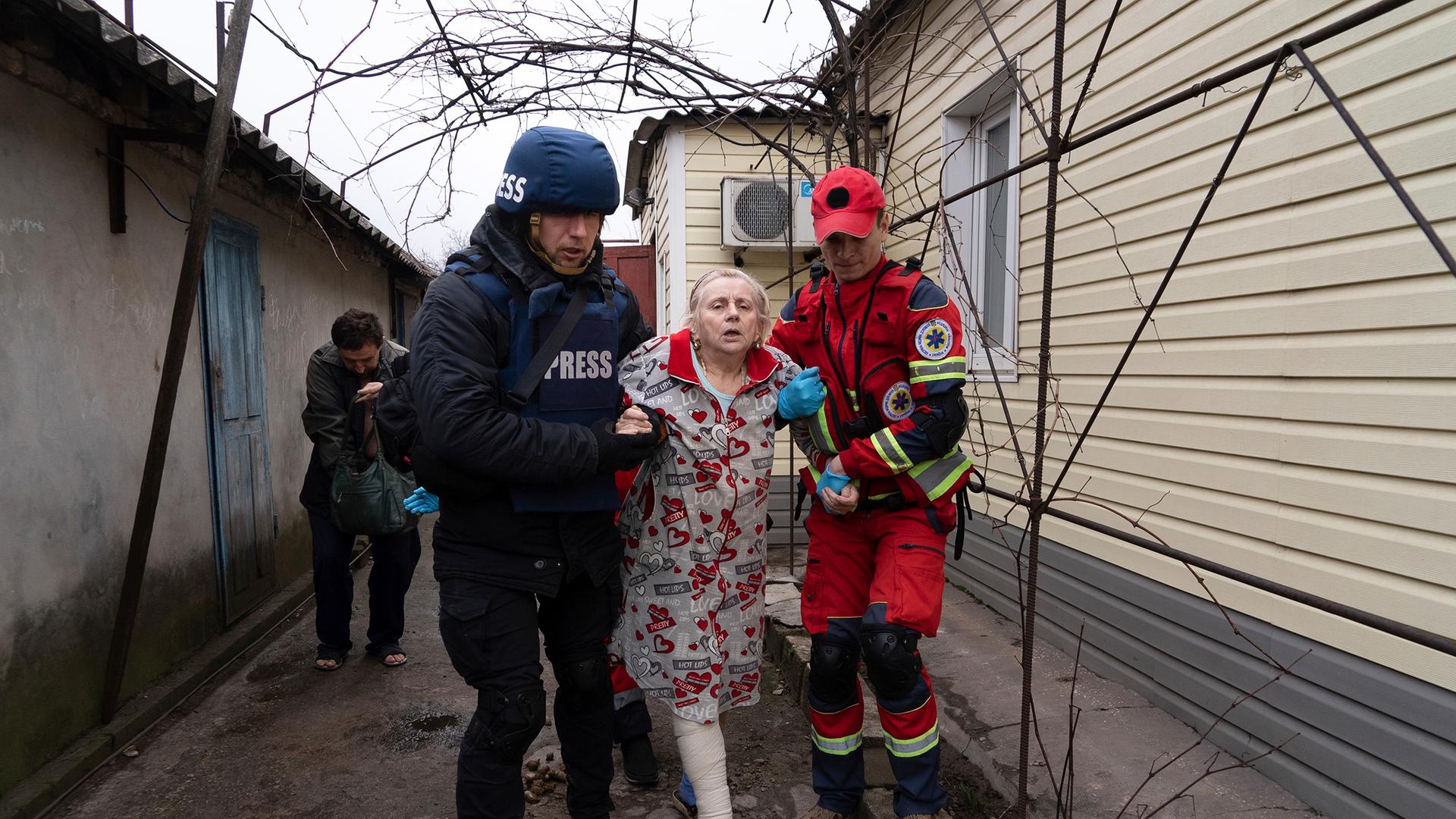 AP-Fotograf Evgeniy Maloletka hilft einem Sanitäter, eine Verletzte zu transportieren.