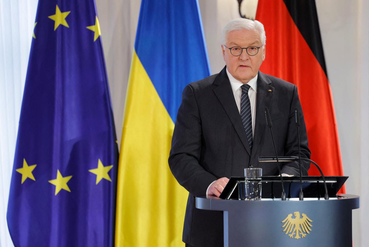 Bundespräsident Steinmeier steht an einem Redepult. Er trägt einen schwarzen Anzug und eine schwarze Krawatte. Im Hintergrund sieht man die ukrainische und die deutsche Flagge sowie die Flagge der EU. Bundespräsident Steinmeier steht an einem Redepult. Er trägt einen schwarzen Anzug und eine schwarze Krawatte. Im Hintergrund sieht man die ukrainische und die deutsche Flagge sowie die Flagge der EU.