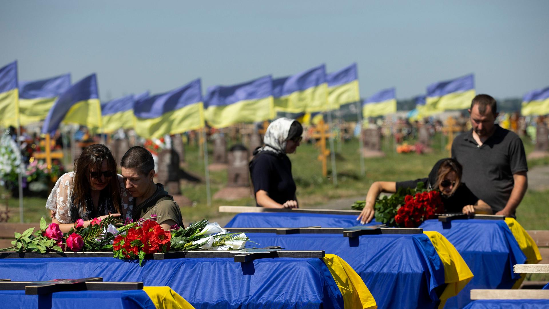 Angehörige und Freunde nehmen an der Begräbnisfeier für 13 an der Front gefallenen ukrainische Soldaten teil. Die Särge sind in einer Reihe aufgestellt und jeweils mit einer ukrainischen Fahne abgedeckt. Angehörige und Freunde nehmen an der Begräbnisfeier für 13 an der Front gefallenen ukrainische Soldaten teil. Die Särge sind in einer Reihe aufgestellt und jeweils mit einer ukrainischen Fahne abgedeckt.