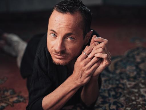 Erwin Aljukic posiert liegend für ein Pressefoto.